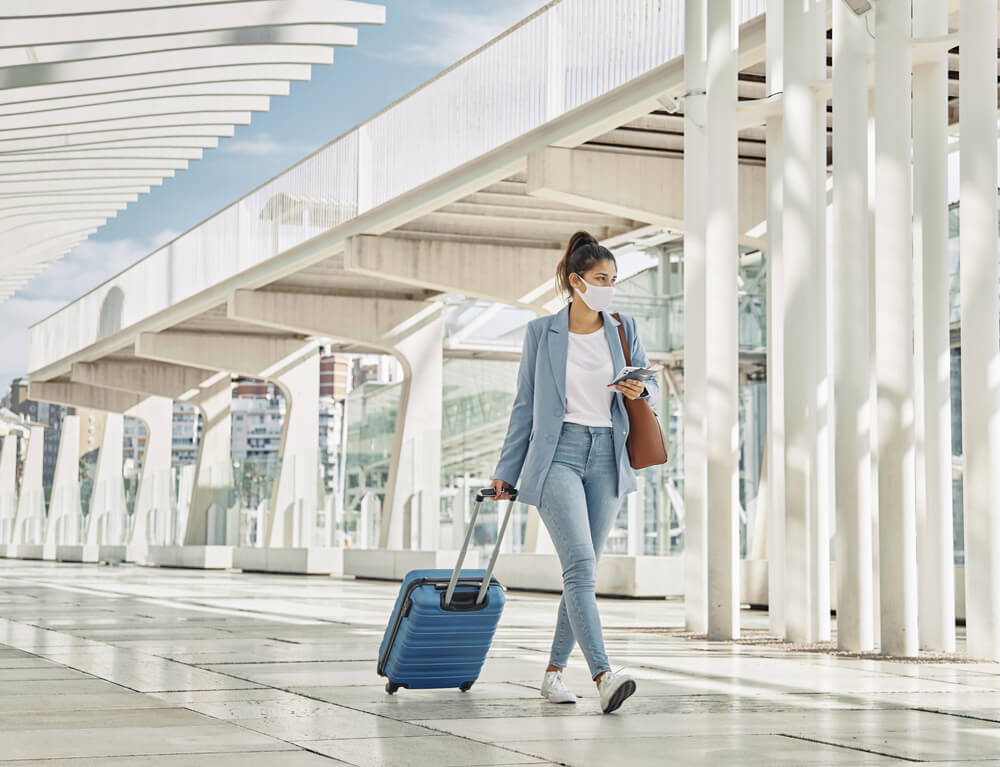 Chica joven portando una maleta en el aeropuerto.